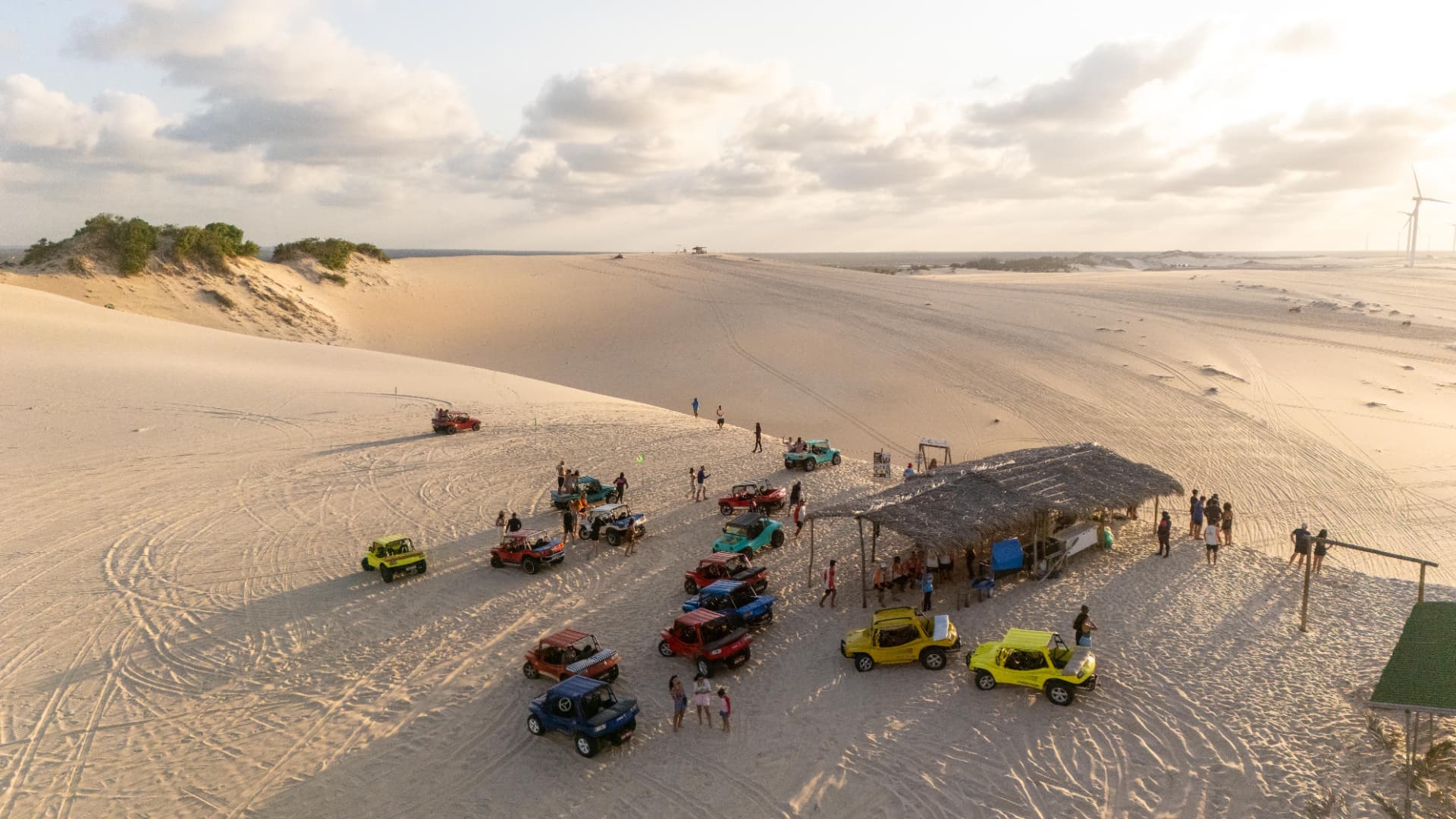 Grupo de buggies em parada nas dunas ao pôr do sol