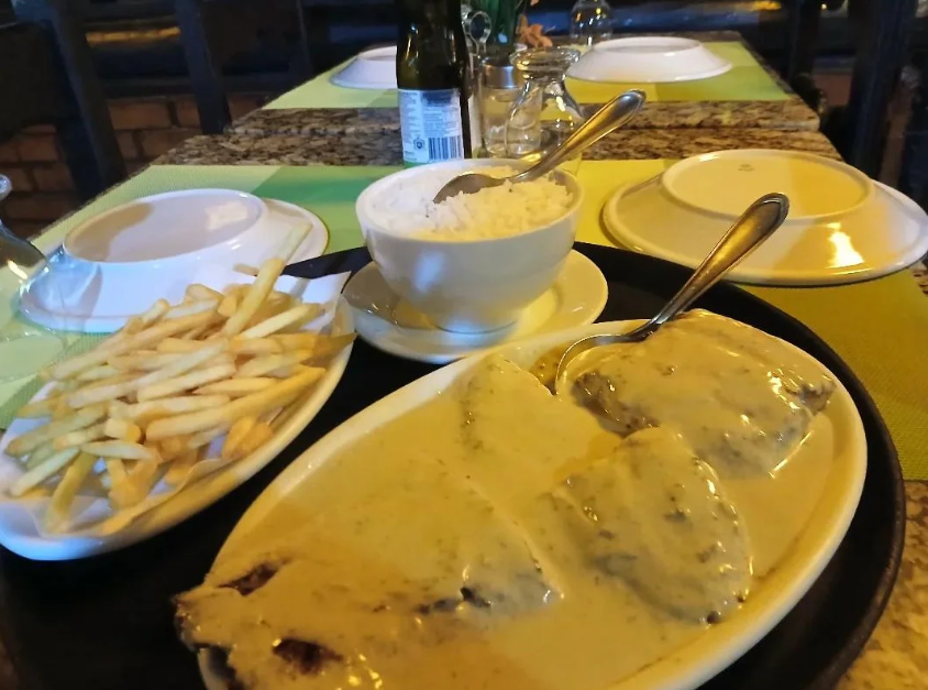 Pratos servidos no Cabana com arroz, fritas e filé ao molho